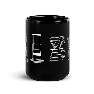 Könnte beinhalten: Schwarze Kaffeetasse mit weißen Strichzeichnungen verschiedener Kaffeezubereitungsmethoden. Die Tasse hat eine glänzende Oberfläche und eine zylindrische Form. Die Designs umfassen eine French Press, eine Aeropress und ein Pour-Over-Setup.