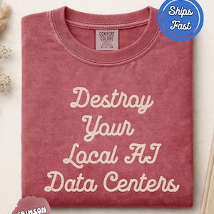 Puede incluir: Una camiseta de cuello redondo color carmesí con el texto en color crema "Destroy Your Local AI Data Centers" impreso en una fuente cursiva de estilo vintage en el pecho. La prenda incluye una etiqueta de la marca Comfort Colors en el cuello.