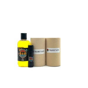 May include: A collection of TransTape products, including a yellow liquid in a bottle, a black tube, and two cylindrical containers. The bottle has a black cap and a label with the TransTape logo. The cylindrical containers have a TransTape label.