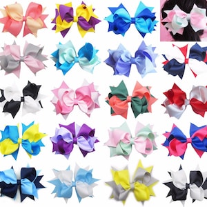 Op de afbeelding: Een verzameling kleurrijke haarstrikken in verschillende tinten, waaronder roze, blauw, paars en geel. Elke strik heeft een gelaagd ontwerp met een stervormig accent. De strikken zijn gemaakt van een satijnachtig materiaal en zijn geschikt voor diverse kapsels.