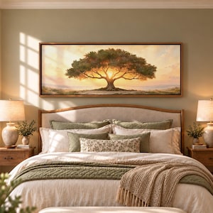 May include: A panoramic landscape wall art print featuring a large, spreading tree silhouetted against a bright, golden sunset sky. The artwork is framed in a thin, light-toned wooden frame and is mounted horizontally above a bed.