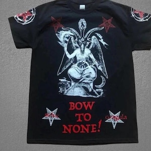 May include: A black short-sleeve t-shirt featuring a white graphic of a horned figure with wings, surrounded by red pentagrams on the chest and sleeves. The text "BOW TO NONE!" is printed in red lettering below the central graphic design.