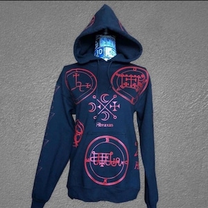 May include: A navy blue hooded sweatshirt with red sigils and the word "Abraxas" printed on the front. The sweatshirt features a drawstring hood and a kangaroo pocket. The sleeves have a star design.