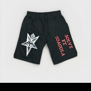 May include: Black shorts with a drawstring waist and a white pentagram graphic. The shorts have the words "SOLVE ET COAGULA" printed in red on the right leg.