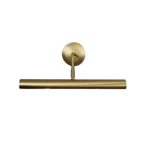 May include: A brass-coloured picture light. It features a circular wall mount, a curved arm, and a horizontal, cylindrical light bar. The fixture is designed to illuminate artwork or other wall-mounted items.