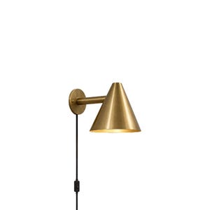 Peut inclure: Une applique murale dotée d'un abat-jour conique en laiton et d'une plaque murale circulaire. Le luminaire est relié à un bras horizontal droit et comprend un cordon d'alimentation noir avec un interrupteur intégré suspendu verticalement.