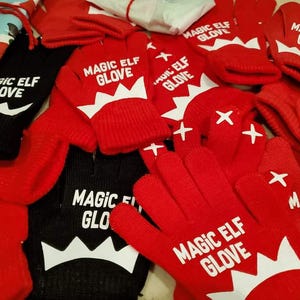 May include: A collection of red and black gloves with the text "MAGIC ELF GLOVE" in white. The gloves have a white zig-zag design and white star accents. Some gloves are mittens, others have individual fingers.