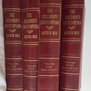 Peut inclure: Quatre livres reliés bordeaux intitulés The Children's Encyclopedia par Arthur Mee, volumes sept, huit, neuf et dix. Chaque dos présente des lettres dorées, des motifs décoratifs et les plages de pages imprimées sur la partie inférieure.