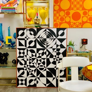 May include: A black and white geometric abstract art print with circles, squares, and triangles. The print is framed in a thin, brown wood frame.