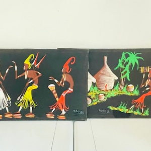 May include: Three black canvas paintings with colorful depictions of African people in traditional clothing. The paintings are titled "Wakou" and feature figures dancing, playing music, and carrying items on their heads.