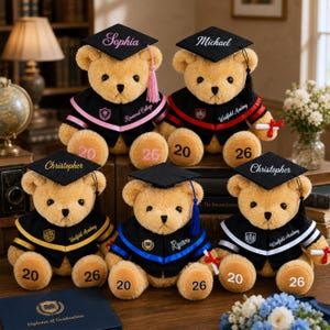 Puede incluir: Varios osos de peluche de graduaci&oacute;n, con birretes y togas negras. Cada oso tiene un nombre bordado en el birrete y el a&ntilde;o 20 o 26 en sus patas. Los osos visten diferentes colores escolares, algunos sosteniendo peque&ntilde;os diplomas.