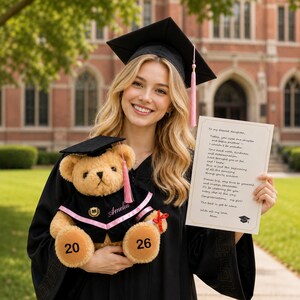 Puede incluir: Una persona con toga y birrete de graduaci&oacute;n sostiene un oso de peluche con un atuendo de graduaci&oacute;n y una tarjeta. El oso de peluche tiene los n&uacute;meros "20" y "26" en sus patas. La tarjeta tiene texto.