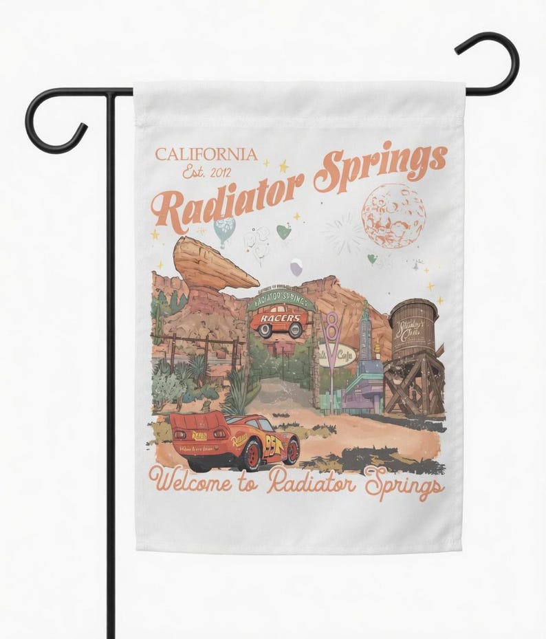 May include: A white garden flag featuring a colorful illustration of Radiator Springs, with the text "CALIFORNIA Est. 2012 Radiator Springs" and "Welcome to Radiator Springs." The design includes a red race car and desert landscape.