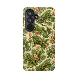 Op de afbeelding: Een smartphonehoesje met een herhalend patroon van groene leguanen, tropische monsterabladeren, palmbladeren en oranje en witte hibiscusbloemen op een lichtcrème achtergrond, met een zwarte cameramodule met drie ronde lenzen.
