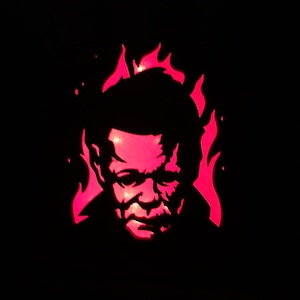 May include: A black silhouette of a person's face with flames behind it. The face is lit from behind with a red light.