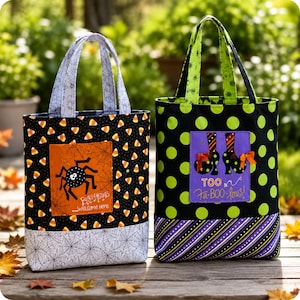 May include: Two fabric tote bags with Halloween themes. The left bag features a candy corn pattern, a spider graphic on an orange square, and a spiderweb base. The right bag has green polka dots, a purple square with witch boots, and striped trim.