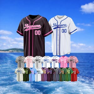 Puede incluir: Camisetas de béisbol en varios colores, incluyendo negro con rayas rosas y blanco con rayas azules. Cada camiseta tiene el texto "Anyname" y el número "00". Se muestran una variedad de otras camisetas debajo.