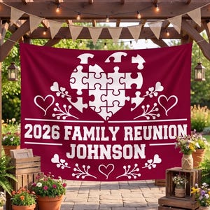 May include: A large rectangular maroon fabric banner featuring a white graphic of a heart made of puzzle pieces. The text 2026 FAMILY REUNION JOHNSON is printed in white block letters, accented by white heart and floral line art designs.