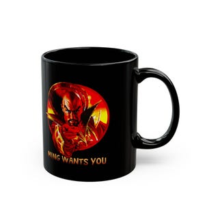May include: Black ceramic mug with a striking image of a character in red and gold, set against a red and yellow backdrop. The gold text reads "MING WANTS YOU". The mug has a curved handle.