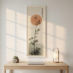 May include: A vertical framed wall art print featuring a black ink bamboo stalk against a large, pale orange circular sun. A small dragonfly is depicted near the top, with vertical black Chinese calligraphy characters and a red seal stamp.