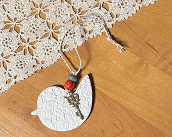 Pequeño dije de pájaro blanco para coche