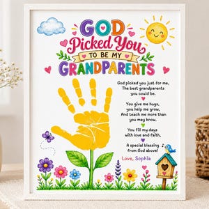 以下が含まれることがあります： God Picked You To Be My Grandparentsという文字、黄色い手形の花、詩、巣箱、カラフルな花のイラストが描かれた白い額縁入りのプリント。デザインには青い雲、黄色い太陽、Love, Sophiaという名前が含まれています。