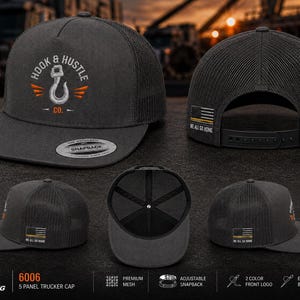 May include: A charcoal gray five-panel trucker cap featuring a mesh back and an adjustable snapback closure. The front displays an embroidered hook logo with the text Hook & Hustle Co. The side features an American flag patch with the text We All Go Home.