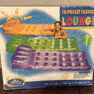 Op de afbeelding: Een rechthoekige kartonnen doos voor een opblaasbaar 18-pocket fashion lounge zwembadmatras. De doos toont oranje, groene en paarse luchtbedden met ingebouwde bekerhouders. De tekst vermeldt 18-POCKET FASHION LOUNGE en 188 cm x 71 cm.