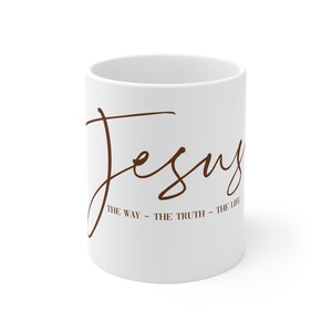 Könnte beinhalten: Weiße Keramik-Tasse mit dem Wort "Jesus" in brauner Schrift. Darunter die Worte "THE WAY - THE TRUTH - THE LIFE" in kleinerer brauner Schrift. Die Tasse hat eine Standardgröße.