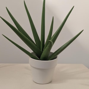 May include: A set of three ceramic mugs with a speckled, matte finish. The mugs are in shades of cream, light gray, and dark gray. Each mug has a simple, minimalist design, perfect for coffee or tea.