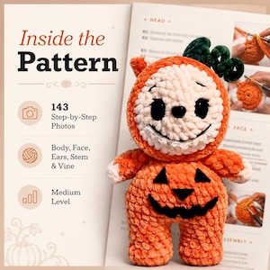 May include: A plush crochet pumpkin doll with a white face, black eyes, and a stitched smile, featuring a dark green stem and vine on top. The doll has a jack-o'-lantern body with black felt eyes and a mouth, displayed over a pattern instruction sheet.