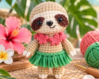 May include: A crocheted sloth amigurumi toy featuring a tan body, dark brown eye patches, and black safety eyes. The sloth wears a pink crocheted flower lei around its neck and a green crocheted grass skirt around its waist, with white claws.
