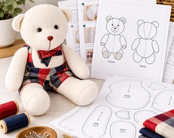 May include: A cream-colored plush teddy bear wearing red and blue plaid overalls and a matching bowtie, accompanied by printed sewing pattern instructions, fabric swatches, spools of thread, a bowl of pins, and gold scissors.