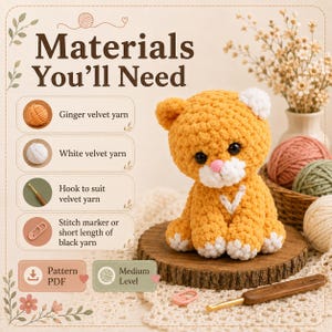 May include: A crochet pattern infographic titled Materials You'll Need, listing ginger and white velvet yarn, a hook, and stitch markers. Beside it sits a plush ginger cat toy with white accents, black eyes, and a pink nose on a wooden base.