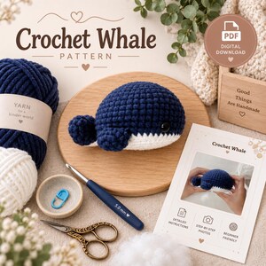 May include: A crochet whale pattern digital download featuring a dark blue and white stuffed whale, a 5.0 mm crochet hook, a blue stitch marker, scissors, and yarn. The text reads Crochet Whale Pattern, PDF Digital Download, and Good Things Are Handmade.