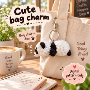 May include: A crocheted panda bag charm featuring a white and black yarn body attached to a silver-toned metal keyring and lobster clasp. The charm is displayed hanging from a beige canvas tote bag with the text Good Things Ahead printed on it.