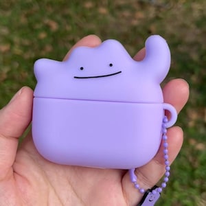 Puede incluir: Una taza de cerámica blanca con un asa negra y el texto "But First, Coffee" en un estilo manuscrito. La taza está sobre una superficie blanca. La taza mide aproximadamente 10 cm de alto.