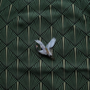 May include: A decorative fabric with a repeating geometric fan pattern in shades of green and black. A white and tan crane with outstretched wings is positioned in the upper right corner, adding a touch of nature to the design.