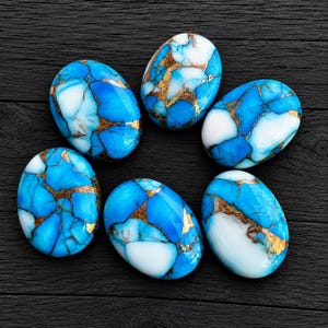 May include: Six oval-shaped cabochons featuring a vibrant blue and white marbled pattern with intricate copper-coloured veining throughout. Each stone has a smooth, polished surface and a distinct, irregular mosaic-like appearance in its colour distribution.
