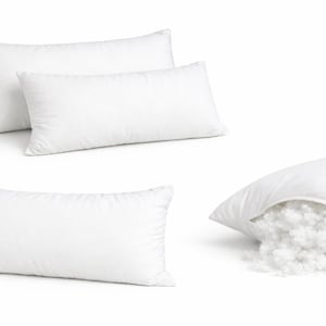 May include: Several white rectangular pillows are displayed, with one cut open to reveal the fluffy filling. The pillows are made of a smooth, white fabric and are designed for comfort and support. The image showcases the pillows' shape and construction.