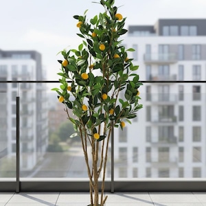 May include: A tall artificial lemon tree in a black pot. The tree has green leaves and yellow lemons. The trunk is brown, and the tree is on a tiled surface with a cityscape in the background.