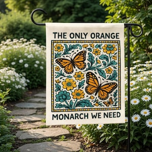 May include: A rectangular garden flag featuring a cream background with a decorative border. The text reads THE ONLY ORANGE MONARCH WE NEED. The design includes two large orange and black monarch butterflies surrounded by yellow flowers and teal leaves.