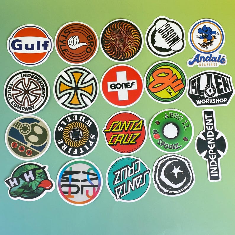 May include: A collection of colorful skateboard stickers with various logos and designs. The stickers feature brands like Santa Cruz, Independent, and Spitfire, with a mix of circular and rectangular shapes. The color palette includes red, blue, green, and orange.