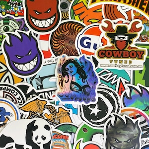 Op de afbeelding: Een verzameling kleurrijke stickers met diverse ontwerpen. De stickers tonen afbeeldingen van een panda, een cowboy, een vrouw en een grijnzend gezicht. Sommige stickers hebben tekst, waaronder "COWBOY TUNED" en "HAPPY".