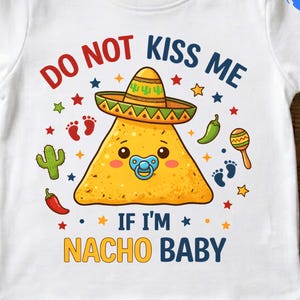 May include: White baby t-shirt with a colorful graphic. The graphic features a cartoon nacho chip wearing a sombrero and a pacifier, with the text "DO NOT KISS ME IF I'M NACHO BABY".