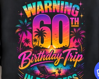 May include: Black sweatshirt with a colorful graphic design. The design features the text "WARNING 60th Birthday Trip In Progress" with a tropical sunset scene, palm trees, and a beach chair.