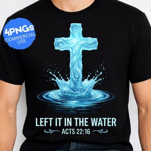Op de afbeelding: Zwart T-shirt met een blauw kruisontwerp dat uit water oprijst, met de tekst "LEFT IT IN THE WATER" en "ACTS 22:16". Het ontwerp bevat waterdruppels en rimpelingen voor een dynamisch effect. Een blauwe cirkel met "4PNGs COMMERCIAL USE" staat linksboven.
