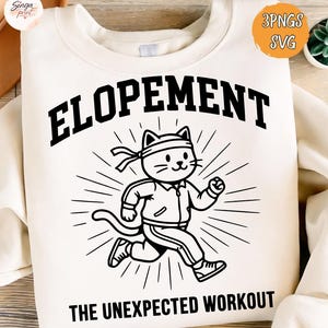 May include: Cream-colored sweatshirt with the word "ELOPEMENT" in bold black letters above a cartoon cat wearing a headband and track suit, running. Below the cat, the text reads "THE UNEXPECTED WORKOUT".