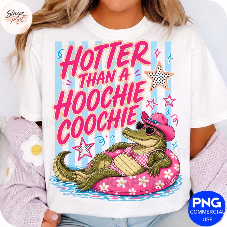May include: White t-shirt with the text "HOTTER THAN A HOOCHIE COOCHIE" in pink. The graphic features an alligator wearing a pink hat and sunglasses, floating on a pink floral inner tube. Blue and pink stars and stripes complete the design.