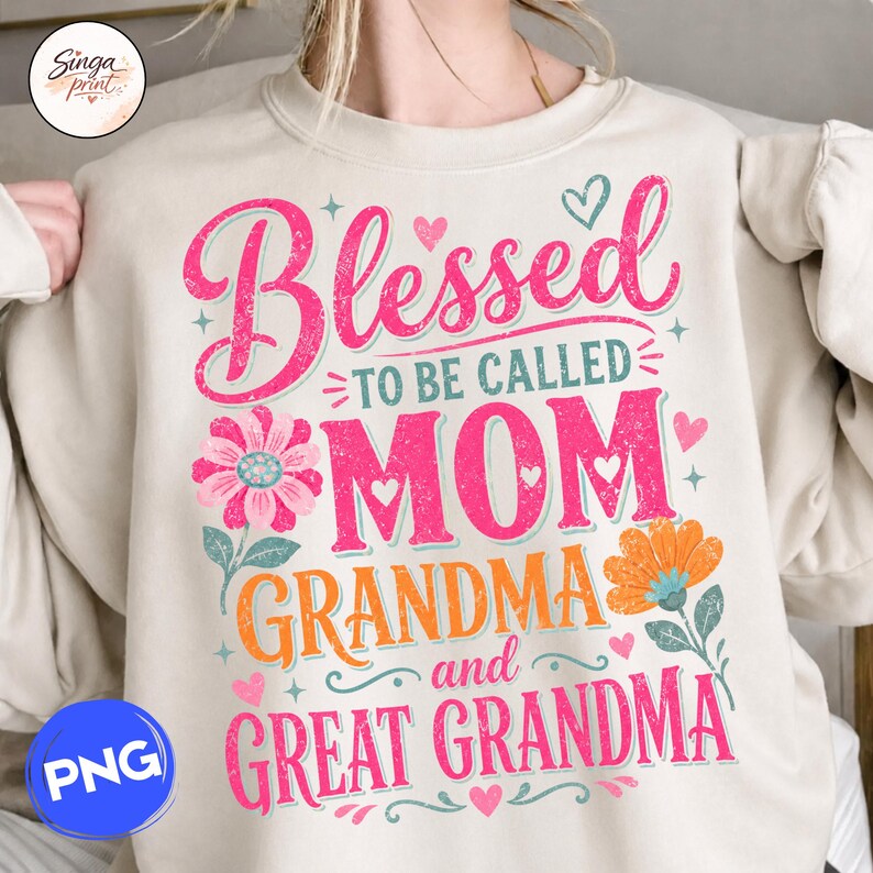 May include: A beige sweatshirt featuring the text "Blessed to be called Mom Grandma and Great Grandma" in pink and orange. The design includes floral and heart motifs, ideal for a gift.
